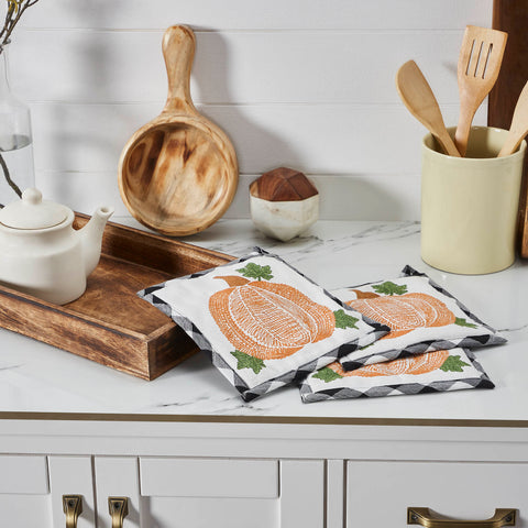 The Annie Black Check Pumpkin Trivet Set includes three trivets measuring 8x8 inches each. The heat-resistant kitchen pads features buffalo check fabric with a thick layer of thermal cotton batting to protect from hot pots and pans. A whimsical pumpkin design is featured on the front with a convenient hanging loop.
