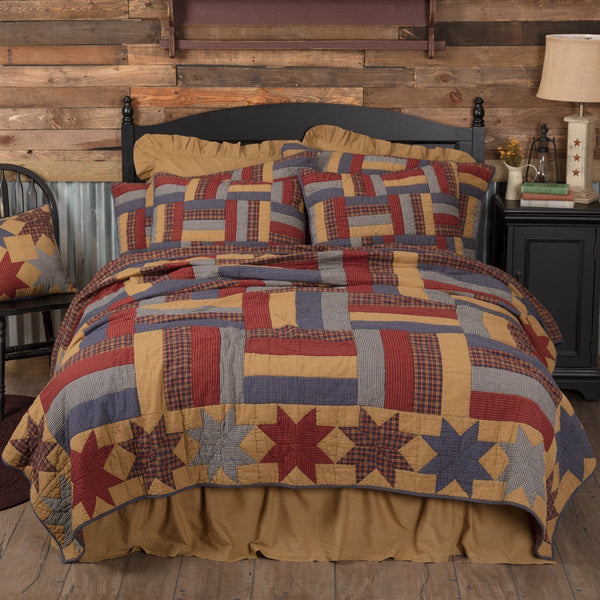 Kindred Stars and Bars Bedding, featuring tan, navy, and rust red plaid in confetti strip blocks surrounded by alternating 8 point star patches. Primitive Country Farmhouse Quilted Bedding Home Decor.