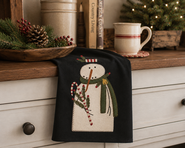 Mr. Winterberry Christmas towel featuring a snowman with greenery, berries, and candy cane accents on a black background.