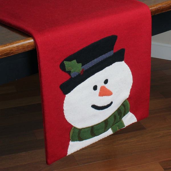 Flurry the Snowman Christmas table runner featuring cheerful snowmen on a barn red background with wool applique details.