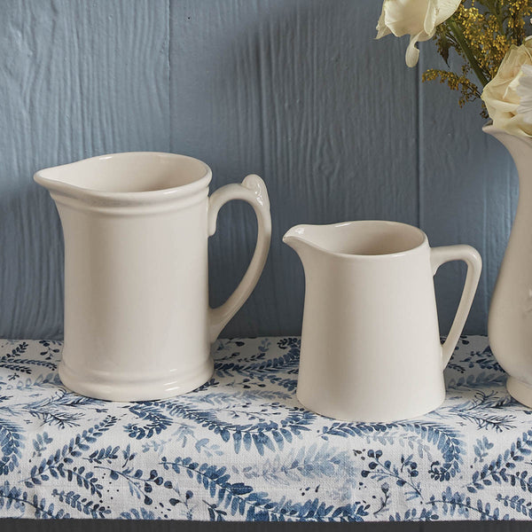 With the curves and detail of vintage style, this sturdy Tavern Pitcher in candlelight white will beautifully accent any country table. Pictured on left with Stoneware Milk Pitcher.