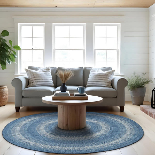 Denim blue sky round braided jute rug with light blue and white accents in a bright farmhouse living room