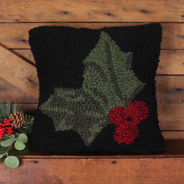 Holly Hooked Pillow featuring green holly leaves and bright red berries on a black hooked wool background.
