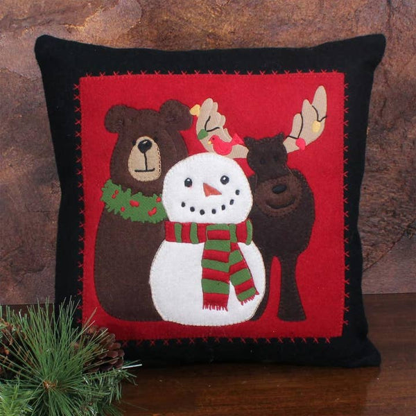 14"x14" holiday pillow with snowman, bear & moose appliqué. Cozy red & black farmhouse accent—perfect on a chair, bench, or bed.