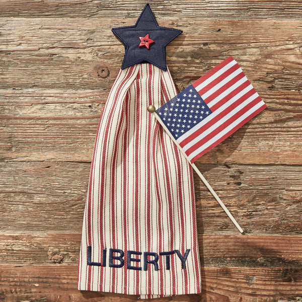 Star Spangled Liberty Hand Towel! Featuring a navy blue star on top with a red button star in the center, it mimics Old Glory herself! The towel is red and white striped with the words Liberty along the bottom. This collection is a lovely tribute to our country that can be used not just on July 4th, but all year long!  Specifications  Colors: Darkest Navy, Patriotic Red & White Dimensions: 17.75"H x 7.25''W