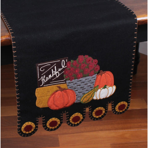 Primitive black wool felt table runner featuring pumpkins, gourds, sunflowers, and Farmers Market appliqué accents.