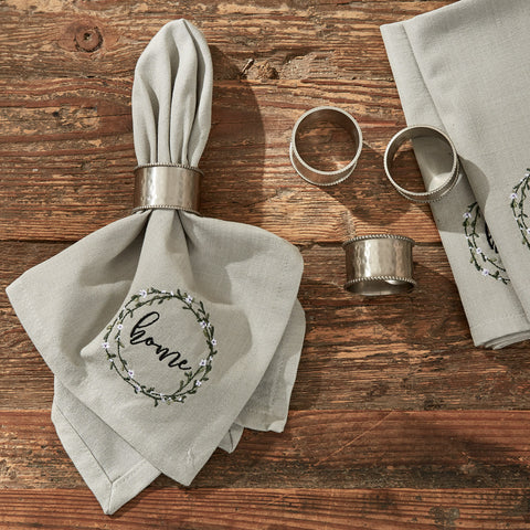 Bouquet Of Grace Napkin features a gray background with a beautiful circle of flowers, with the word "home"