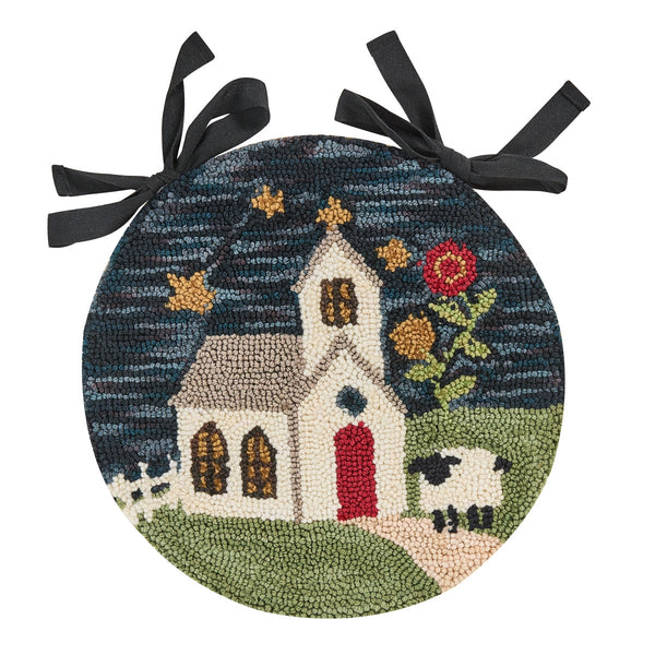 Chapel On The Hill hooked chair pad featuring a country church, sheep, flowers, and stars on a dark blue background with attached ties.