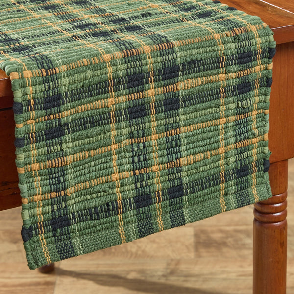 Add rustic charm with the Willow Lane Chindi Table Runner 13"x36". Woven plaid in green, gold & black brings cozy farmhouse style to any table.