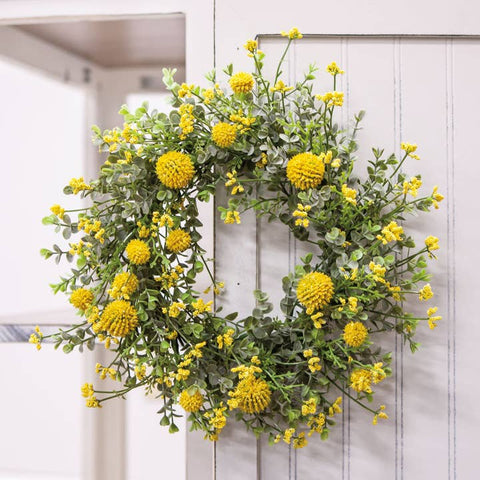 Garden Bliss Candle Ring features plastic, vibrant yellow woolly heads and eucalyptus leaves. Can be hung as a small wreath accent or used with pillar candles. Measures a 6" inside diameter and a 10" outside diameter.