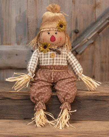 Edgar primitive scarecrow doll with burlap hat, sunflower accents, plaid shirt, and raffia details for fall harvest decorating.