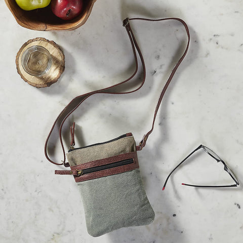 This crossbody is the perfect size to keep your items secure when you're on the go. Made from durable re-milled and up-cycled military tarps & tents used by the army, covering trucks as tarps and providing shelter as tents, this textile is given new life..