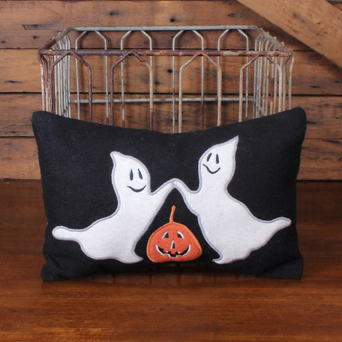 Primitive Halloween pillow with two dancing white ghosts and an orange jack-o’-lantern on a black background