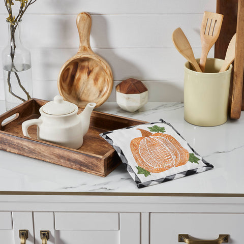 The Annie Black Check Pumpkin Trivet includes one trivet measuring 8x8 inches. The heat-resistant kitchen pad features buffalo check fabric with a thick layer of thermal cotton batting to protect from hot pots and pans. A whimsical pumpkin design is featured on the front with a convenient hanging loop