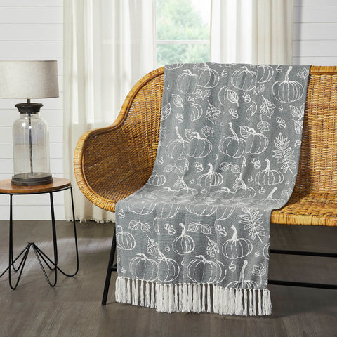Modern warm grey meets a traditional pumpkin print for updated fall style. The Silhouette Pumpkin Throw measures 50x60 inches and features a deep grey base accented by a charming pattern of pumpkins, acorns and leaves in soft cream. Cream tassels add a finishing touch at each end of the throw blanket. Sling on the back of a chair or sofa for a perfect splash of autumn style. Machine washable and iron safe.
