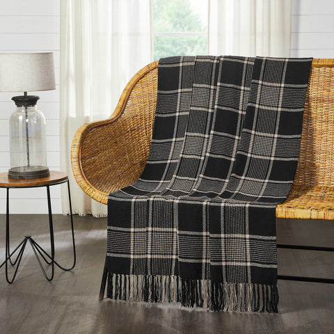 Deep black and natural tan create a traditional tartan plaid for updated fall style. The Eston Black Tan Plaid Throw measures 50x60 inches and features a black base with natural tan striping. Soft tassels add a finishing touch at each end of the throw blanket. Sling on the back of a chair or sofa for a perfect splash of autumn style. Machine washable and iron safe.