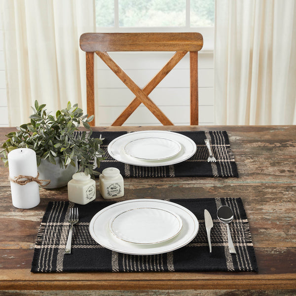 Create the perfect table settings with a timeless feel. The Eston Black Tan Plaid Placemat Set includes two placemats measuring 13x19 inches each. The table place settings are constructed with a single layer of a cotton polyester blend and includes a fringed edge. The black base features deep tan stripes in a traditional tartan plaid pattern.