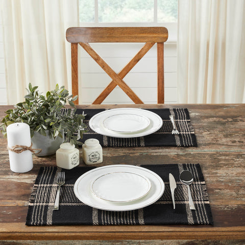 Create the perfect table settings with a timeless feel. The Eston Black Tan Plaid Placemat Set includes two placemats measuring 13x19 inches each. The table place settings are constructed with a single layer of a cotton polyester blend and includes a fringed edge. The black base features deep tan stripes in a traditional tartan plaid pattern.