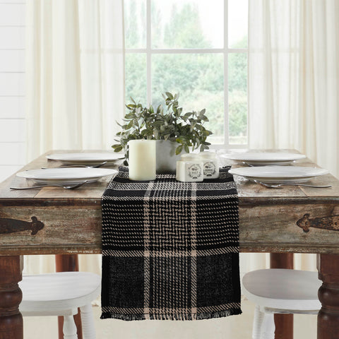 Give your tabletop decor a seasonal upgrade with traditional plaid in deep tones. The Eston Black Tan Runner measures 12 by 36 inches and features a woven base in recycled cotton with frayed edging. The dark fall table runner features a black base with deep tan striping. 