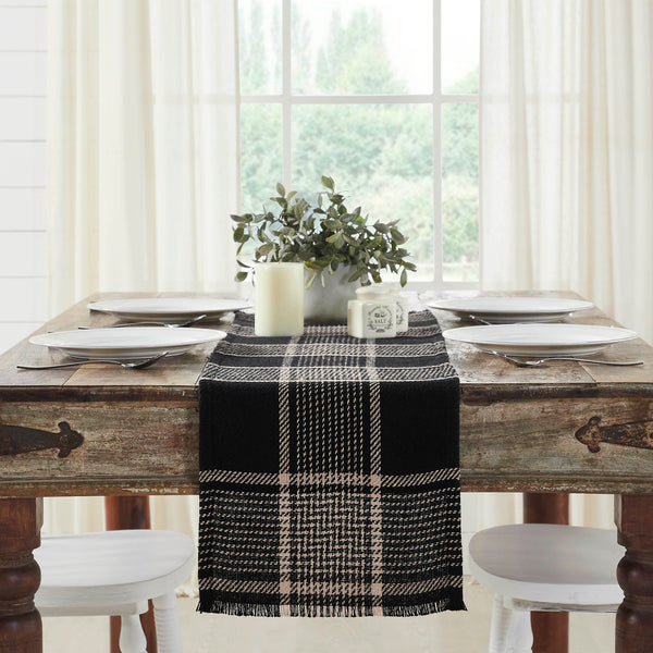 Give your tabletop decor a seasonal upgrade with traditional plaid in deep tones. The Eston Black Tan Runner measures 12 by 48 inches and features a woven base in recycled cotton with frayed edging. The dark fall table runner features a black base with deep tan striping. 