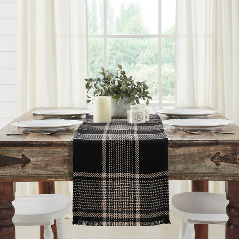 Give your tabletop decor a seasonal upgrade with traditional plaid in deep tones. The Eston Black Tan Runner measures 12 by 48 inches and features a woven base in recycled cotton with frayed edging. The dark fall table runner features a black base with deep tan striping. 