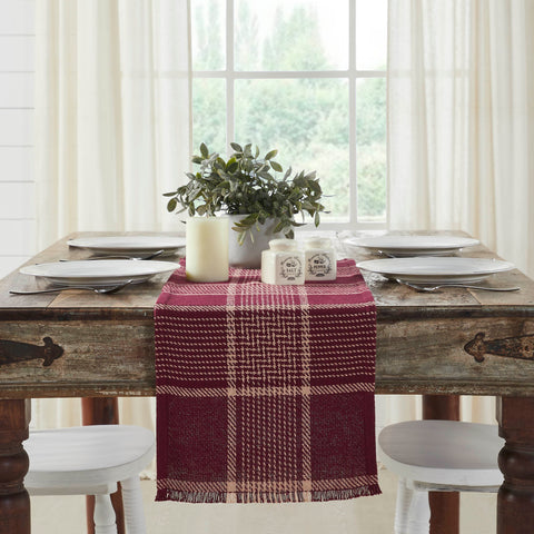 Give your tabletop decor a seasonal upgrade with traditional plaid in deep tones. The Eston Burgundy Tan Runner measures 12 by 36 inches and features a woven base in recycled cotton with frayed edging. The dark fall table runner features a burgundy base with deep tan striping. Pair with other pieces from the Eston Burgundy Tan Plaid Collection by VHC for a timeless farmhouse look.