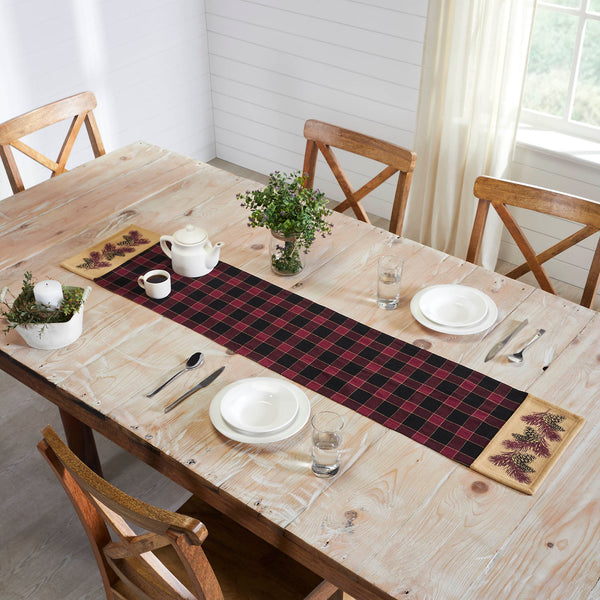 ive your tabletop decor a seasonal upgrade with traditional plaid in deep tones with pinecone accents. The Connell Pinecone Runner measures 12 by 60 inches and features a woven base in 100 percent cotton. The dark fall table runner features a burgundy and black plaid base flanked by tan blocks featuring a primitive pinecone and pine needle design. 