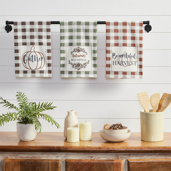 The Bountifall Harvest Tea Towel set includes three tea towels measuring 19x28 inches. The small kitchen towels feature traditional gingham prints in vintage tones of green, gold and brown. Unique word art is included on the bottom of each towel reading, Gather, Autumn Blessings and Bountiful Harvest.