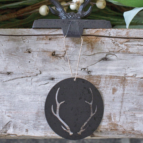 The metal Antler Ornament will add a rustic farmhouse element to your tree this year. Made out of galvanized distressed metal this circular ornament has antler cutouts and features a twine hanger. 