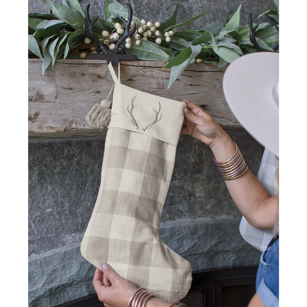 Add a stylish touch to your holiday decor with the Signature Antler Christmas Stocking! Featuring a gray and white check design with embroidered antler accent, these stockings are sure to be a charming addition to your mantle!
