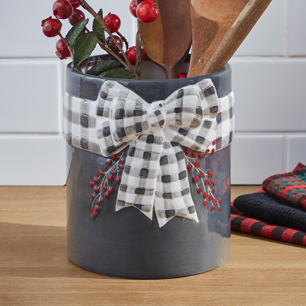 Bring the celebration and magic of the Christmas season to your table with the Home For Christmas Utensil Crock! Features a black and white checked bow with red berries! So very festive and charming!