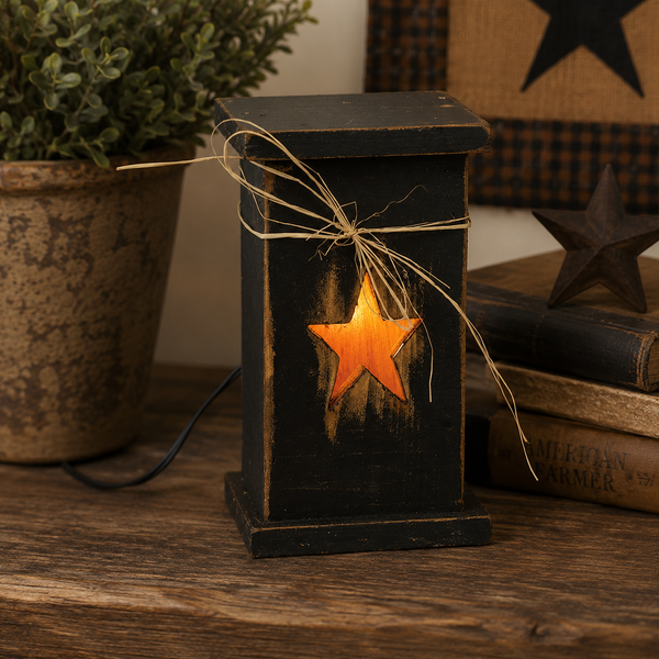 Black rustic wood lighted pedestal with glowing star cutout and raffia bow on top.