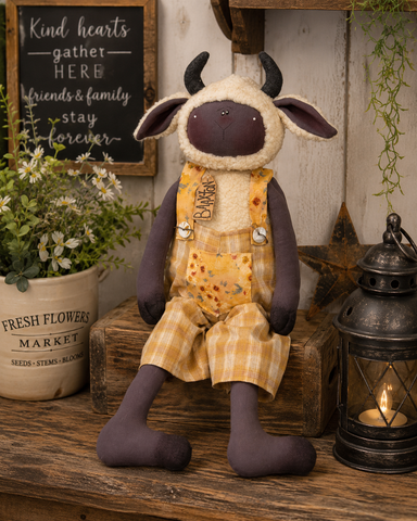 Baaxton the primitive ram doll wearing mustard plaid overalls with felted horns and rustic farmhouse styling.