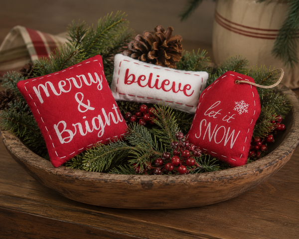 Winter bowl filler set featuring three festive wool pillows with "Merry & Bright," "Believe," and "Let It Snow" designs in red and cream, perfect for dough bowls, baskets, tiered trays, and Christmas decorating.