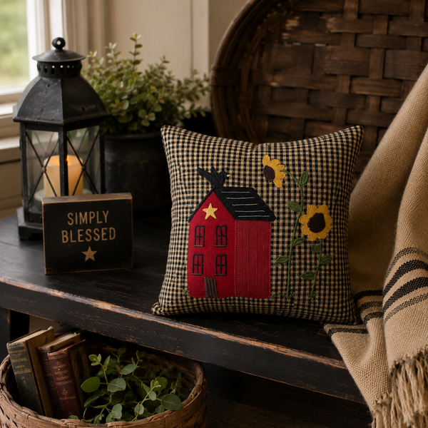Primitive Home Sampler decorative pillow featuring a red house, sunflowers, and crow applique on a black and tan check background.