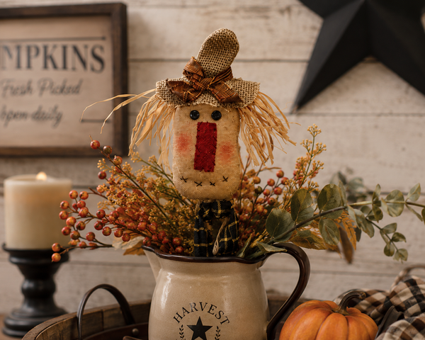 Primitive 15-inch scarecrow floral pick with burlap hat, raffia hair, and gingham bow for fall decorating.