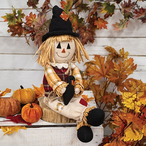 Primitive plaid scarecrow plush shelf sitter holding a crow for fall and harvest decorating.