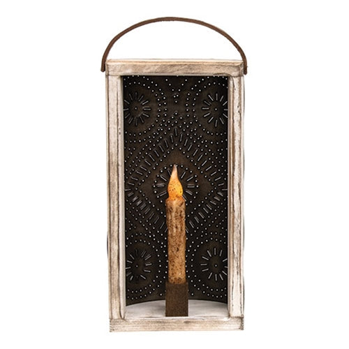 Distressed white wood and dark punched tin candle lantern with decorative floral cutout design, wooden handle and built-in taper candle holder for primitive country home decor.