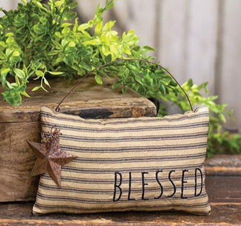 Blessed Ticking Stripe Pillow Ornament with Rusty Star is a stuffed fabric pillow ornament that features the word, ""BLESSED" in black stitching alongside a rusty, metal star on curled wire.