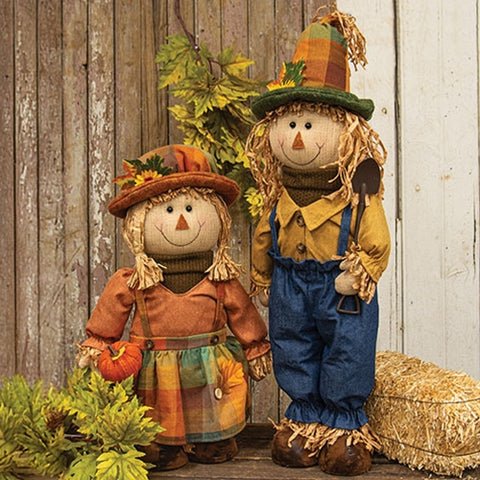 Set of two primitive standing autumn scarecrows with adjustable legs for fall decorating.