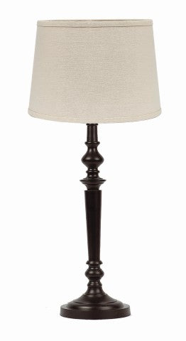 Black primitive farmhouse table lamp with classic turned metal base and neutral shade displayed in a cozy country style room.