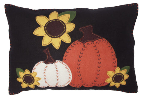 Black wool pillow with orange and white pumpkins, yellow sunflowers, and green leaves appliqué, accented with decorative stitching.