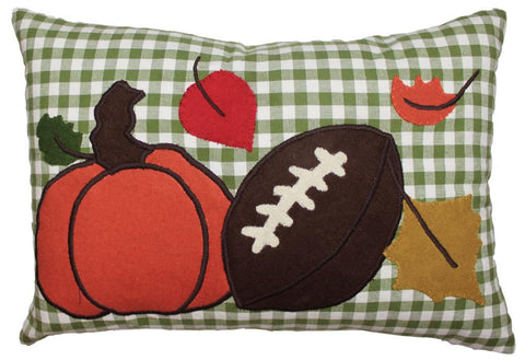 Fall football pillow with pumpkin, football, and leaves on green plaid background.
