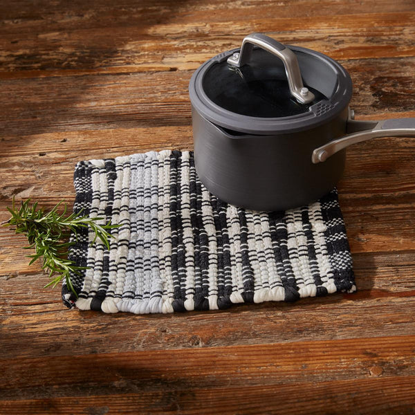 Protect your surfaces from hot pots and pans while adding charming style to your decor with the Refined Rustic Chindi Trivets! Featuring a classic plaid design in tones of antique white, gray, and black, these trivets will be an elegant touch to your country decor! Complete the look with the rest of the Refined Rustic collection!  Colors: Oatmeal, Whisper Greige & Black Set of 4 Dimensions: 8" W x 8" L