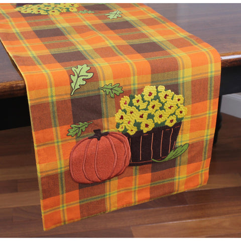 Autumn plaid table runner with embroidered pumpkin and mums on a warm orange plaid cotton background.