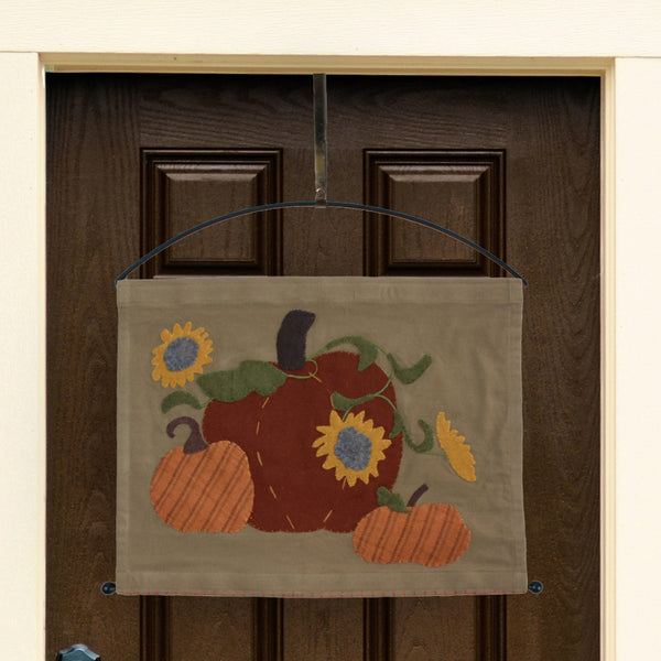 Primitive fall pennant featuring pumpkins and sunflowers on a tan background with wool felt appliqué details.