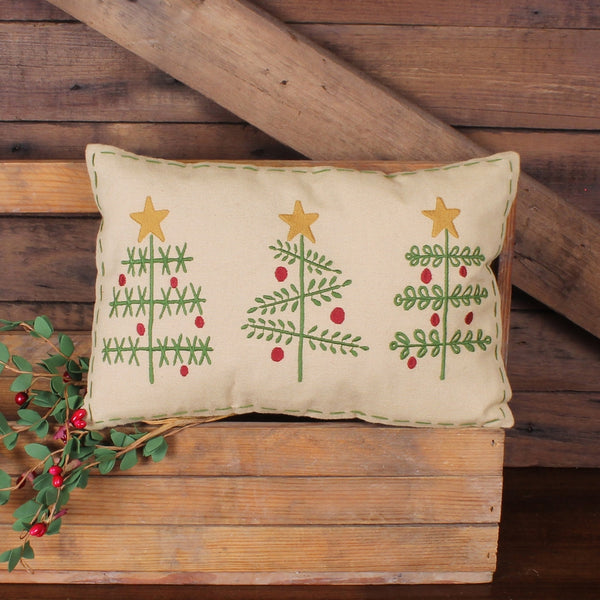 O' Christmas Tree accent pillow featuring three embroidered Christmas trees with red ornaments and gold stars on a tan background with decorative stitch border.