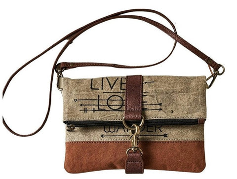 Command the attention of fellow travelistas and sight-see in style with the Live, Love, Wander Collection. Made from up-cycled canvas, this rustic fold-over crossbody is equipped for all your adventures.