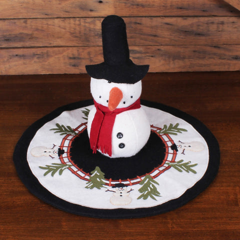 Home For The Holidays Candle Mat featuring embroidered snowmen, evergreen branches, and a rustic wreath design on wool felt for Christmas decorating.