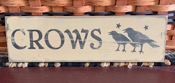Primitive Crows 12” sign is painted antique white over black with black lettering and is sanded and stained for a primitive look. It is routed in the back for easy hanging. This sign measures 12" x 3.5" x .75" and is made from pine wood which may have imperfections such as knots, raised grain or other markings. No two are exactly the same.